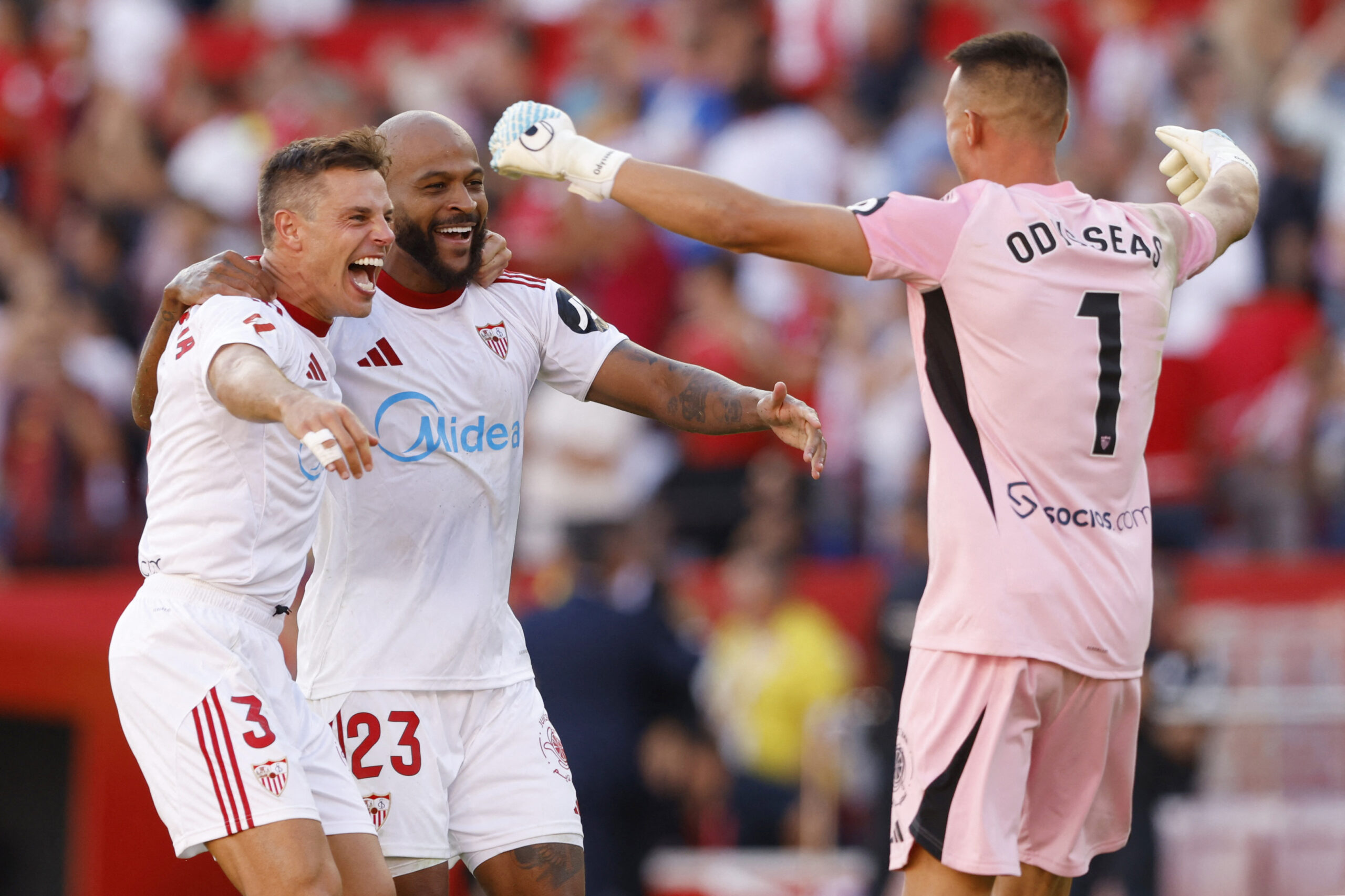 två sevilla spelare och målvakten firar ett mål
